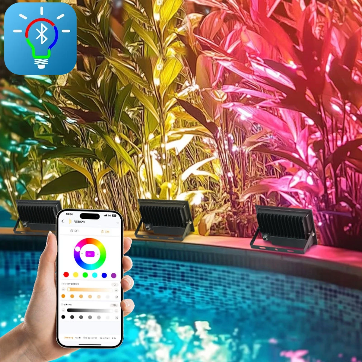 Focos LED RGB+CCT encendidos sobre las plantas junto a la piscina, con colores y luminosidad regulados desde el smartphone a través de la app Fi Light